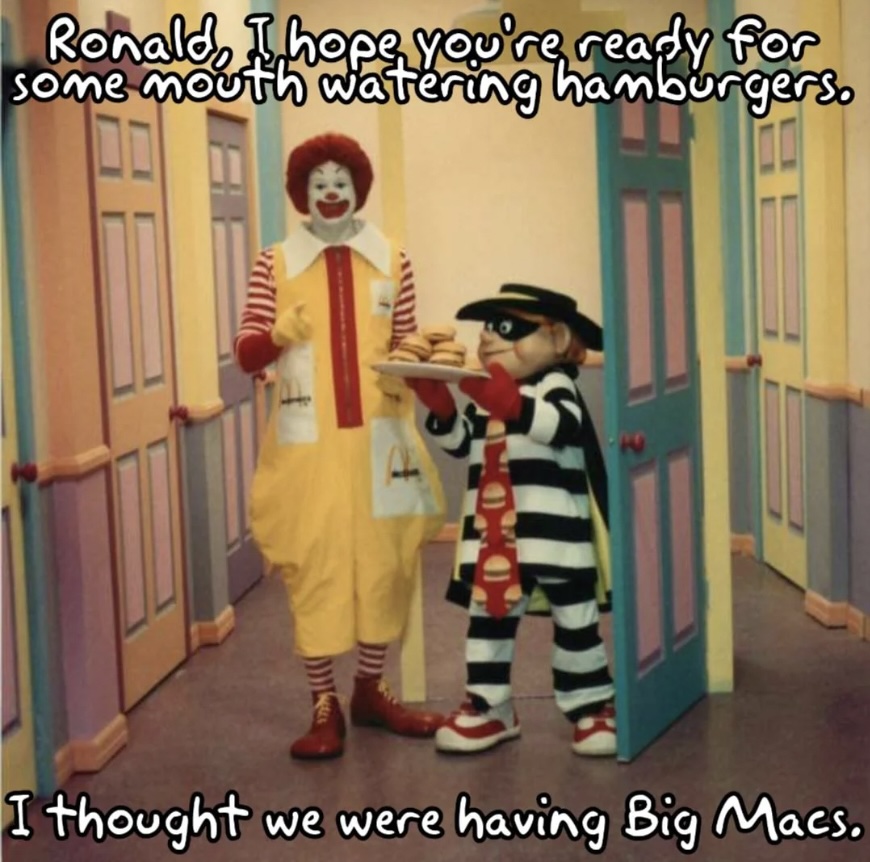 A clown character stands with a striped-suit character holding burgers in a colorful hallway. Text above reads, "Ronald, I hope you're ready for some mouth watering hamburgers." Below reads, "I thought we were having Big Macs.