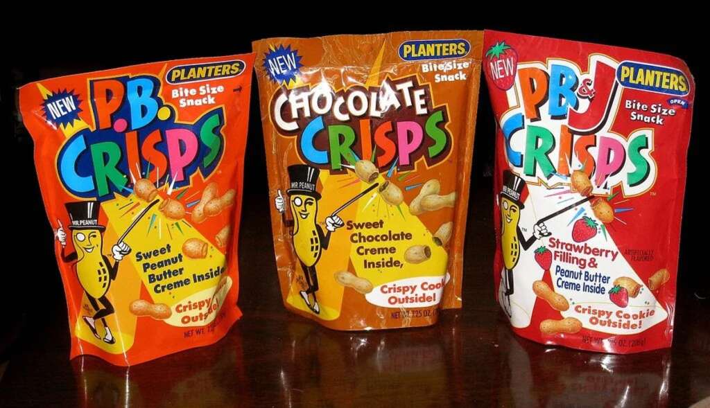 Three colorful snack packages of PB Crisps, featuring Planters branding. The flavors displayed are Sweet Peanut Butter Creme, Chocolate Creme, and Strawberry Filling & Peanut Butter Creme. Each claims a crispy cookie exterior.