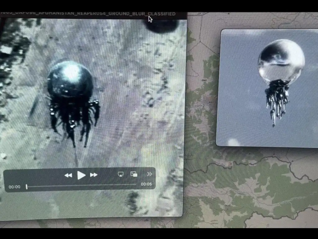 Screens displaying black and white footage of a mysterious metallic orb with dark, dripping tentacles hovering in the air. The background shows a blurred landscape map underneath the video clips.