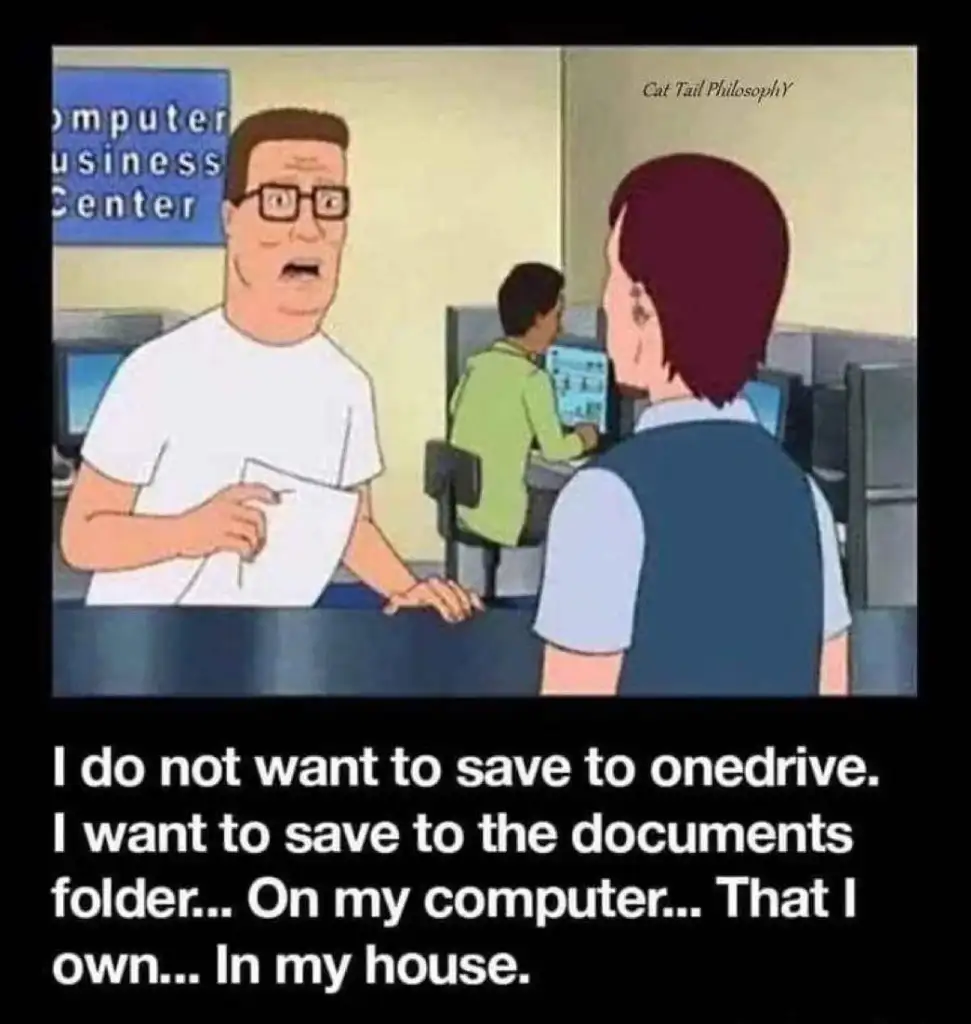 Cartoon scene of a man at a computer business center counter, holding a paper, expressing frustration about saving files. Caption reads: "I do not want to save to onedrive. I want to save to the documents folder... On my computer... That I own... In my house.