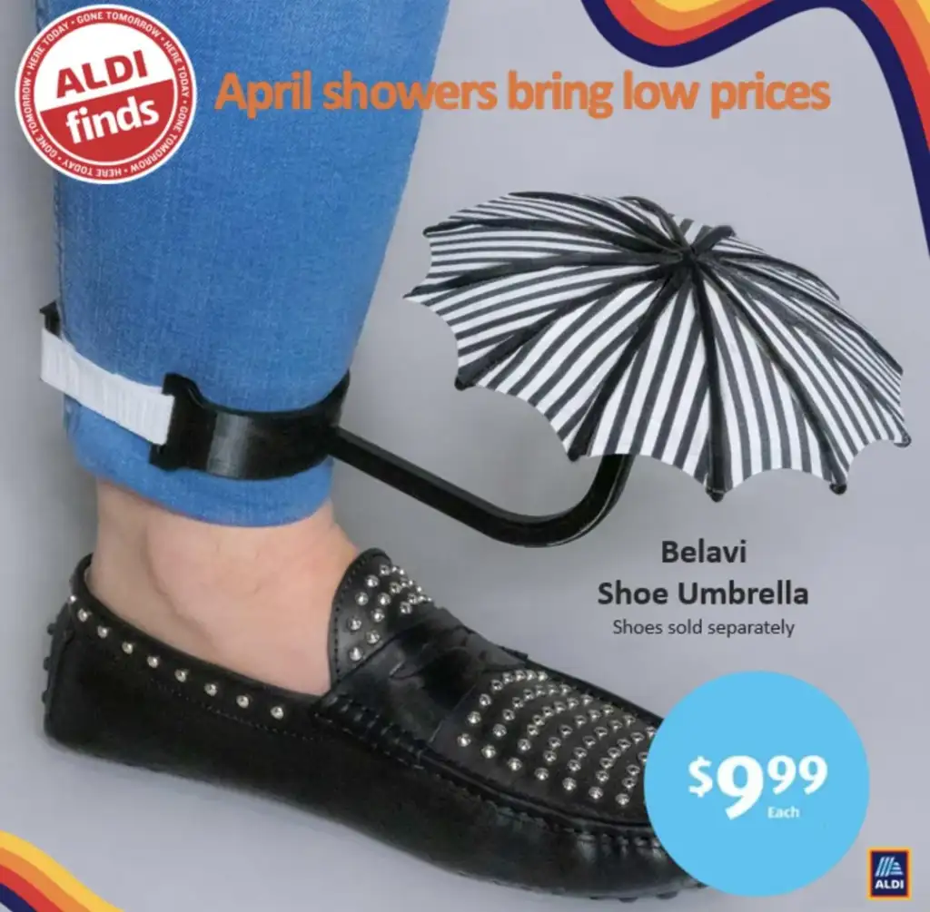 A person wearing blue jeans and black studded loafers displays a small black and white striped umbrella attached to their ankle. Text reads: "April showers bring low prices. ALDI finds. Belavi Shoe Umbrella. Shoes sold separately. $9.99 Each.