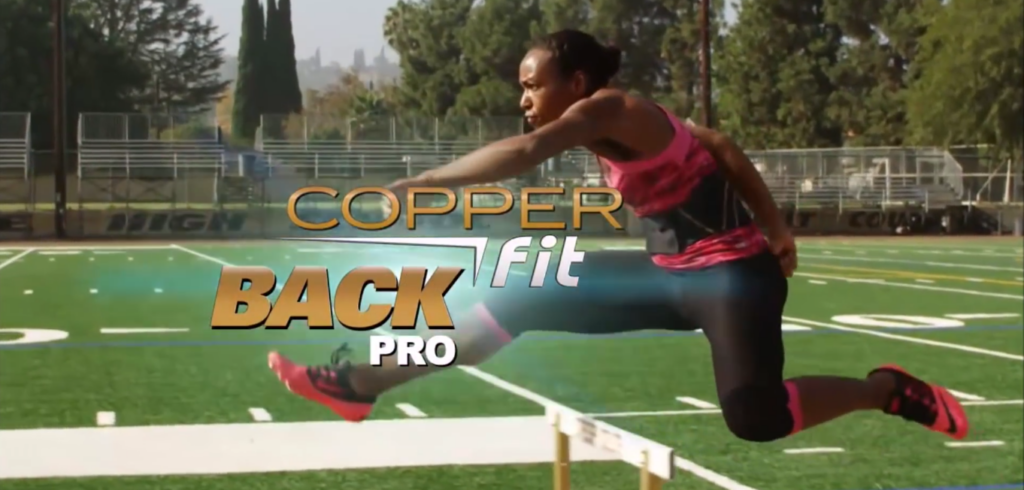 A person in athletic attire is mid-air, leaping over hurdles on a sports field with trees in the background. The text "Copper Fit Back Pro" is overlaid on the image.