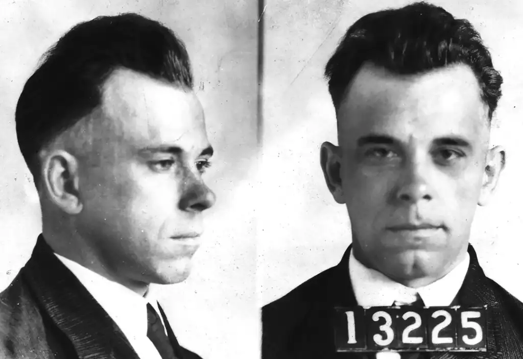 Black and white mugshot photo showing a man with short dark hair in a suit and tie. The image is divided into two views: side profile on the left and front-facing on the right, with the number "13225" under the front-facing view.