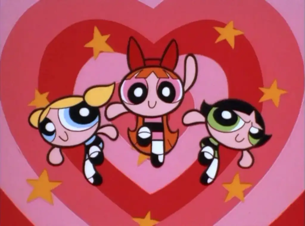 Three animated characters with big eyes and colorful outfits flying against a pink heart background with stars. One has blonde hair, another red, and the last one has black hair. They appear vibrant and cheerful.