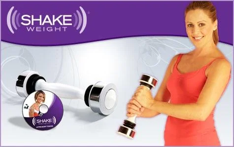 A person in a pink tank top holds a Shake Weight against a purple background. Beside them, a Shake Weight and a fitness DVD are displayed. The text "Shake Weight" is above the items.