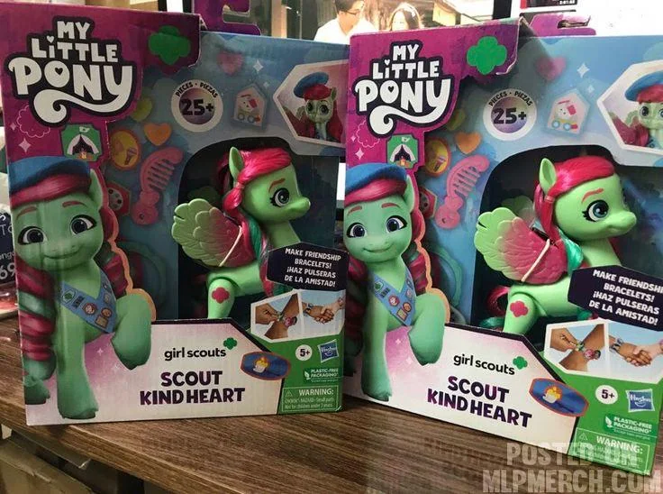 Two boxes of "My Little Pony" featuring "Scout Kind Heart," a green pony with pink and red mane, wings, and the Girl Scouts logo. The packaging includes friendship bracelet-making instructions. Suitable for ages 5+.