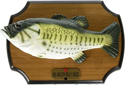 Toy fish mounted on a wooden plaque, resembling a largemouth bass. The plaque has a label reading "Big Mouth Billy Bass" with a red button beneath it.