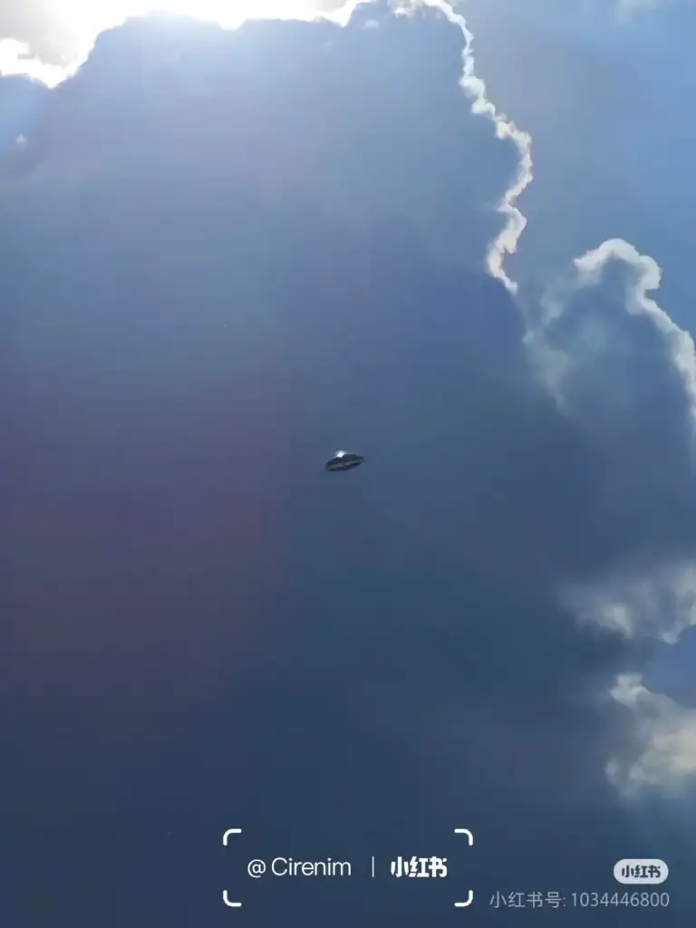 A mysterious flying object in the sky against a backdrop of dramatic clouds and sunlight.