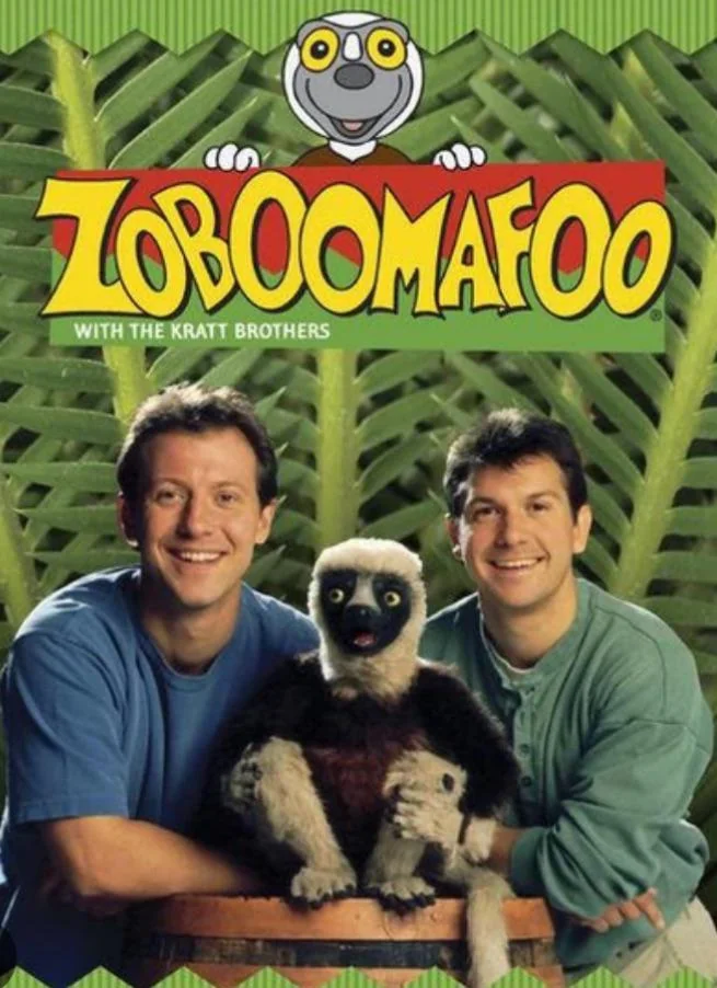 The image shows a poster for "Zoboomafoo" featuring two adults and a lemur in front of a leafy background. The show's title is displayed at the top with a cartoon lemur.