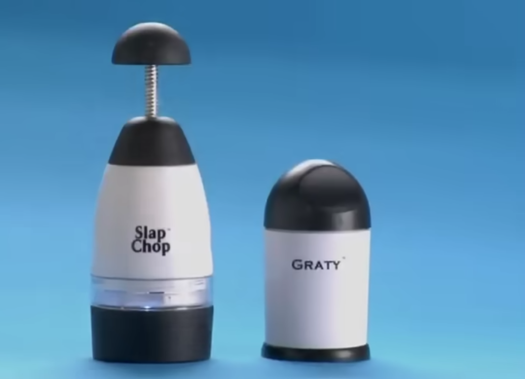 Two kitchen gadgets on a blue background: a black and white "Slap Chop" with a plunger top and a transparent section, and a compact, domed "Graty" next to it.