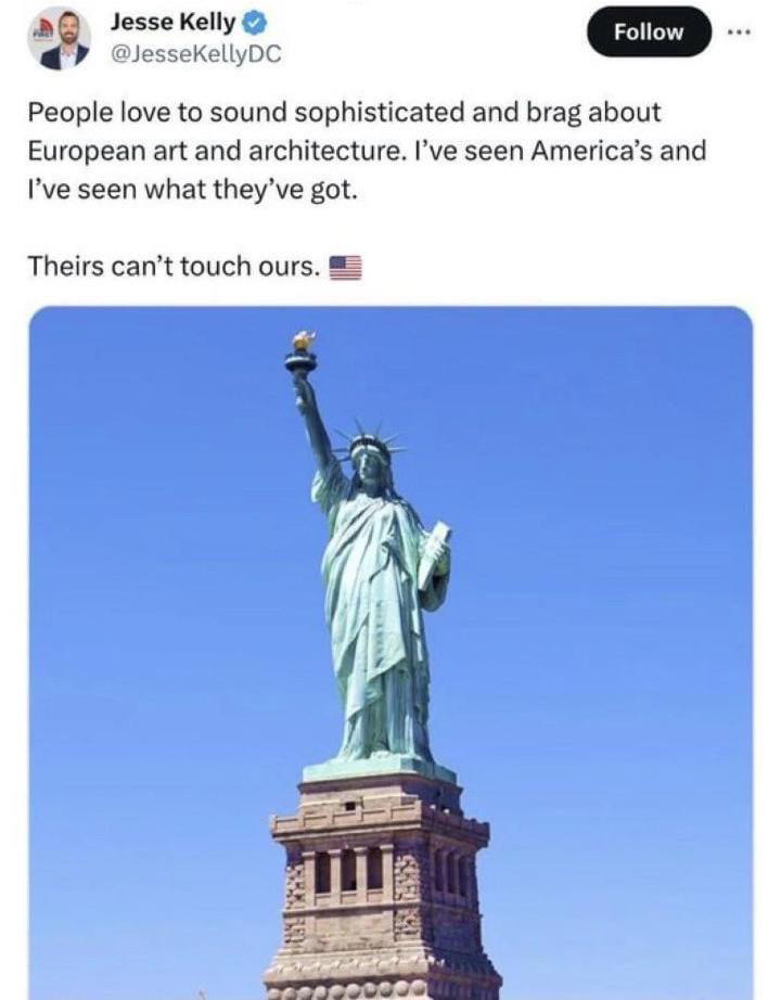 Tweet by Jesse Kelly featuring an image of the Statue of Liberty against a clear blue sky. The caption praises American art and architecture, suggesting it surpasses European counterparts. The post includes an American flag emoji.