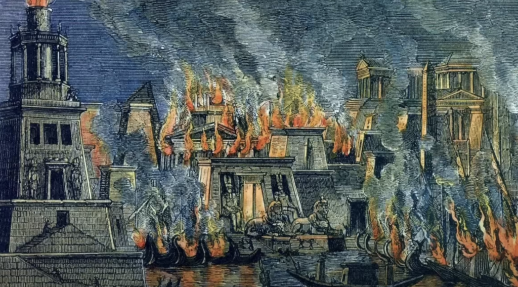 An illustration of the Library of Alexandria in flames, with large fires consuming the buildings. Smoke billows into the sky as boats are seen on the water in the foreground, and ancient architectural details are visible amidst the chaos.