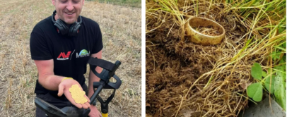 A man in a field holding several gold coins, smiling, with a metal detector next to him. To the right, a close-up of a gold ring partially buried in the grass and soil.