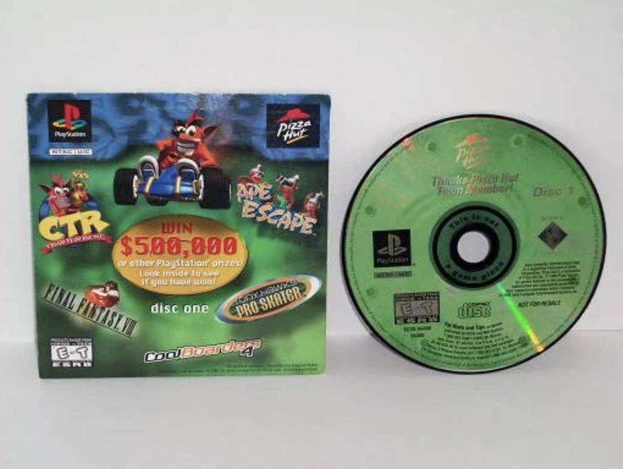 A PlayStation promotional pack featuring a game case with characters from "CTR" and "Ape Escape," along with a disc. The package mentions a chance to win $500,000 and includes logos of Pizza Hut and PlayStation.