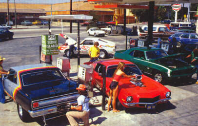 A vintage scene at a bustling gas station with multiple customers fueling their classic cars. The vehicles have distinct colors and hood modifications. Nearby, a gas station sign and retro buildings add to the nostalgic atmosphere.