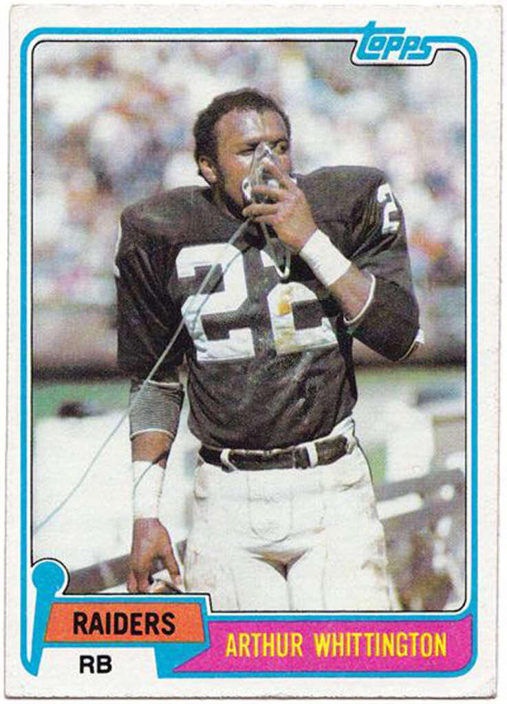 A vintage football trading card featuring a player in a Raiders uniform with the number 22. The player is using an oxygen mask on the sidelines. The card includes the Topps logo and states "Arthur Whittington, RB.