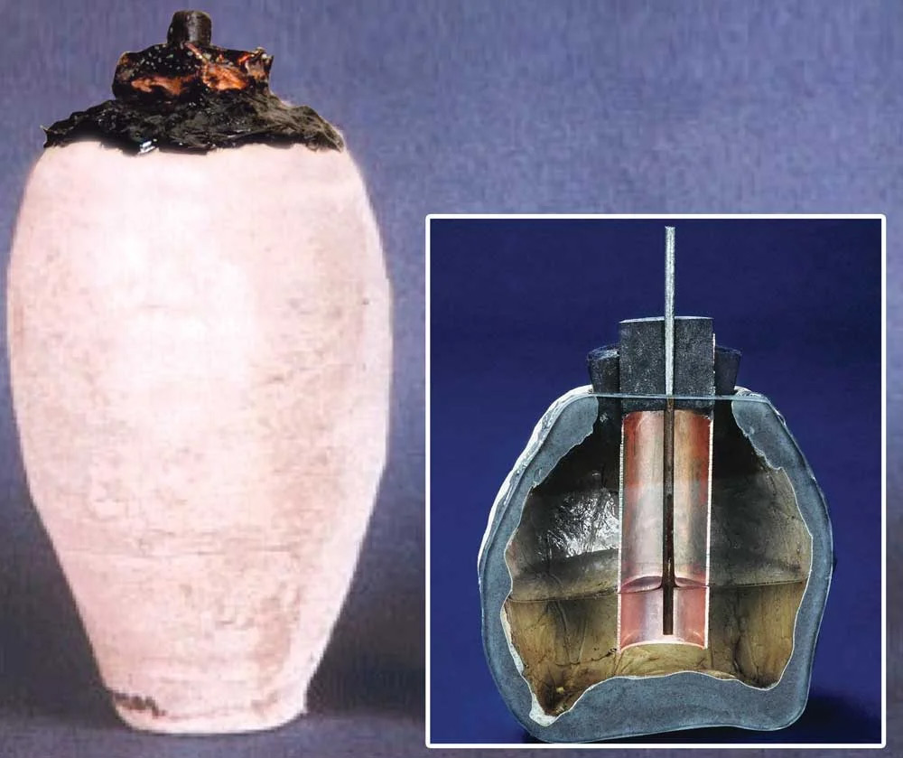 An ancient clay jar, known as the Baghdad Battery is shown. Next to it is a cross-sectional diagram revealing an interior setup with a rod and liquid, resembling a primitive battery design.