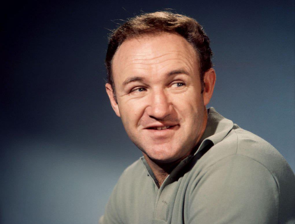 Man with short hair smiling slightly, wearing a light-colored polo shirt, against a blue background.