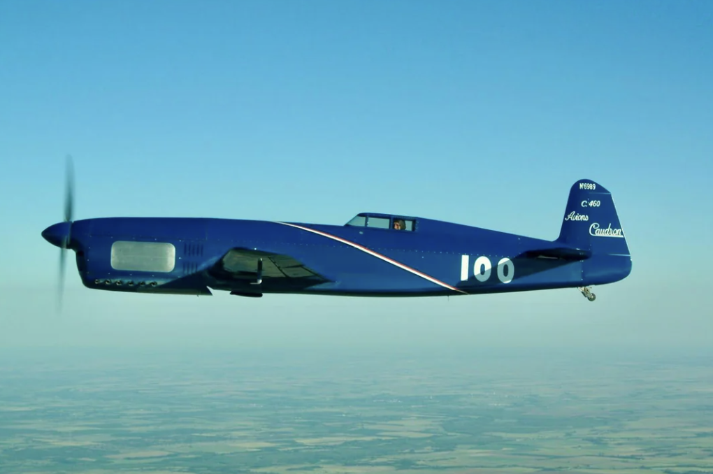 A blue airplane flying in the sky