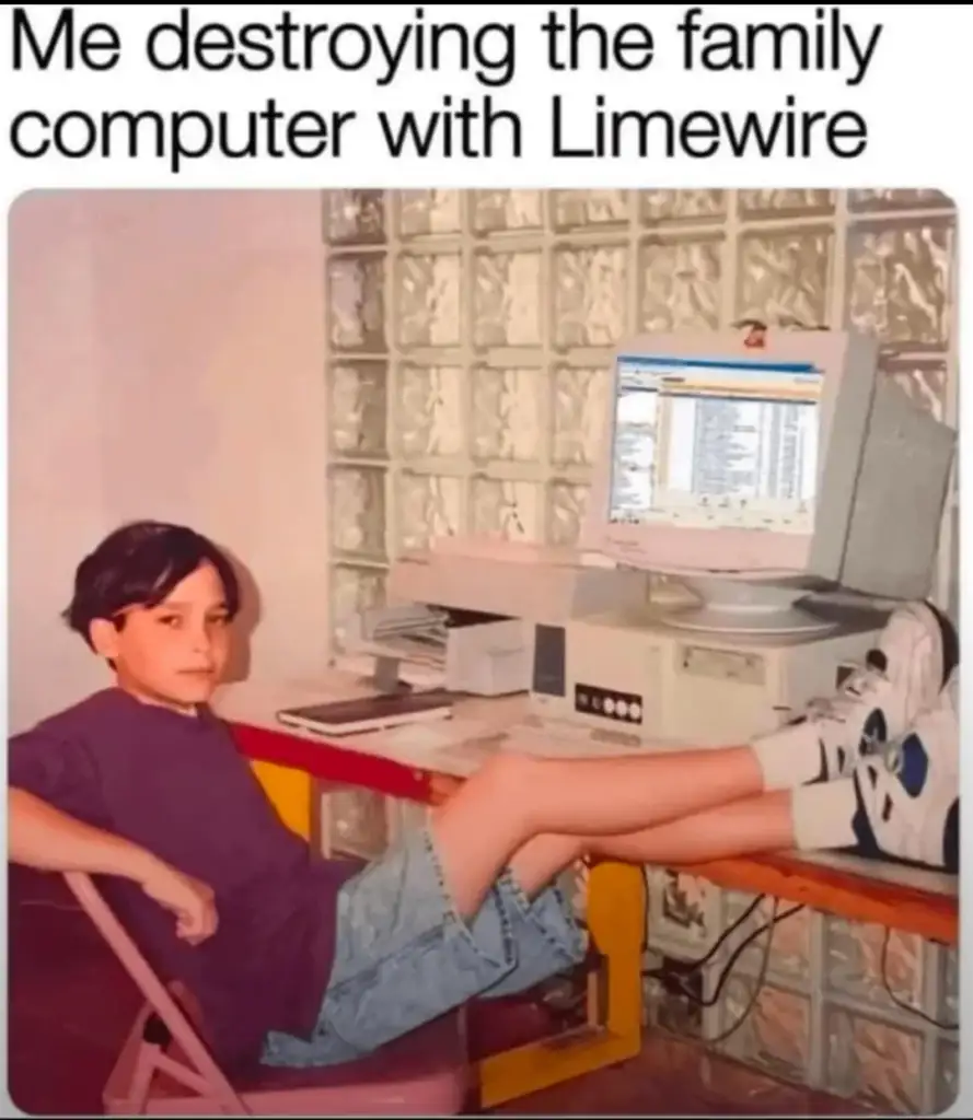 A young boy with dark hair relaxes in a chair, feet on the desk, next to an old desktop computer. The screen shows a program similar to Limewire. Text above reads, "Me destroying the family computer with Limewire.