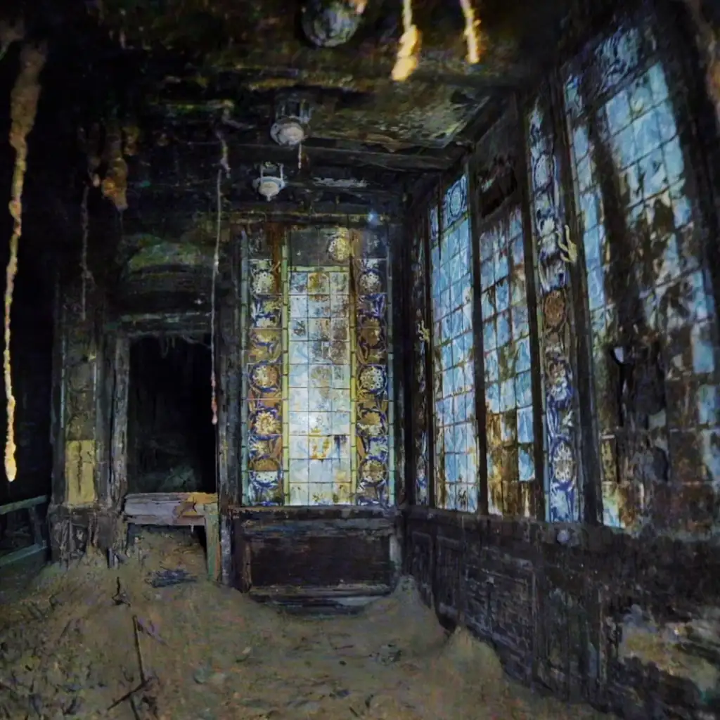 A dimly lit, abandoned room with intricately detailed stained glass windows. The windows depict various ornate patterns and symbols. The floor is covered with debris, and stalactite-like formations hang from the ceiling.