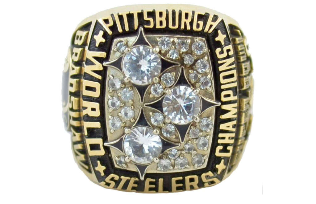 A Super Bowl championship ring featuring the words "Pittsburgh Steelers World Champions" around the edge. The center displays multiple large and small diamonds set in a gold setting.