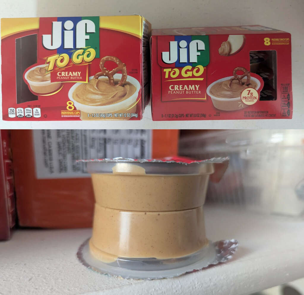 Two boxes of "Jif To Go" creamy peanut butter on a shelf, each containing eight individual cups. One opened cup of peanut butter is placed in front, with its sealed cover peeled back. The packaging features a pretzel dipped in peanut butter graphic.