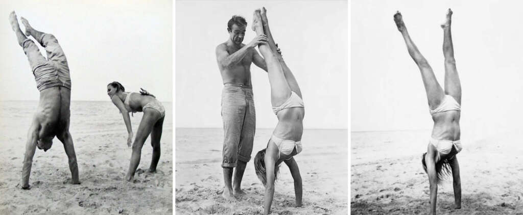 Three black and white photos show a man and a woman on a beach practicing handstands. In the first, the man is upside down. In the second, the man assists the woman with her handstand. In the third, she balances on her hands independently.