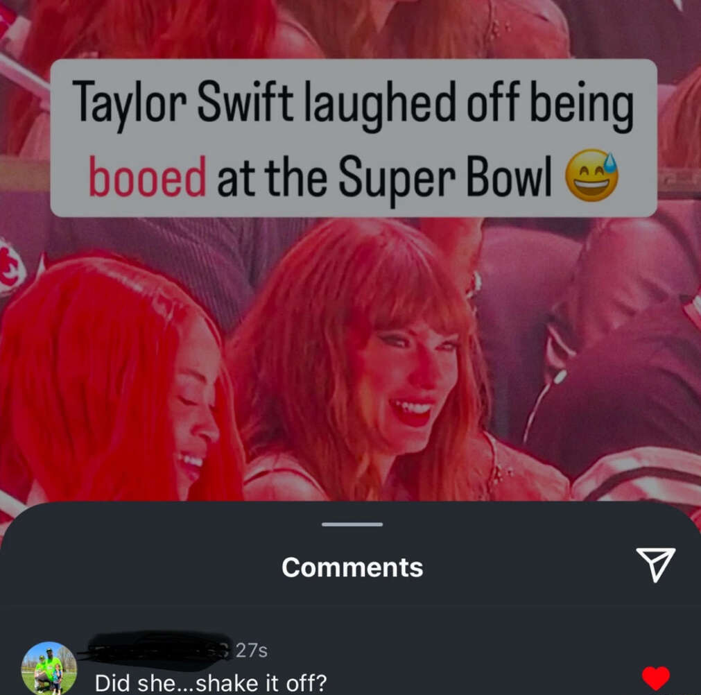 Two women are laughing and smiling in the audience. Text overlay reads, "Taylor Swift laughed off being booed at the Super Bowl," with a winking emoji. Below, a social media comment asks, "Did she...shake it off?" with a heart emoji.