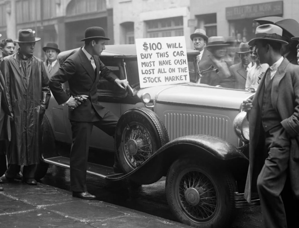 Black-and-white photo of a man standing by a vintage car in the 1920s or 1930s, holding a sign that reads, "$100 will buy this car, must have cash, lost all on the stock market." Several men in suits and hats are gathered around.