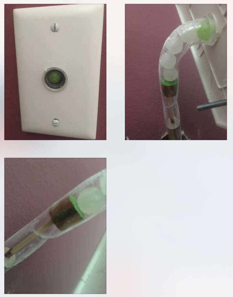 Three images showing a green and white device attached to a wall. The first image shows a button on a white switch plate. The other two images focus on a transparent tube with green and white components connected inside the wall.