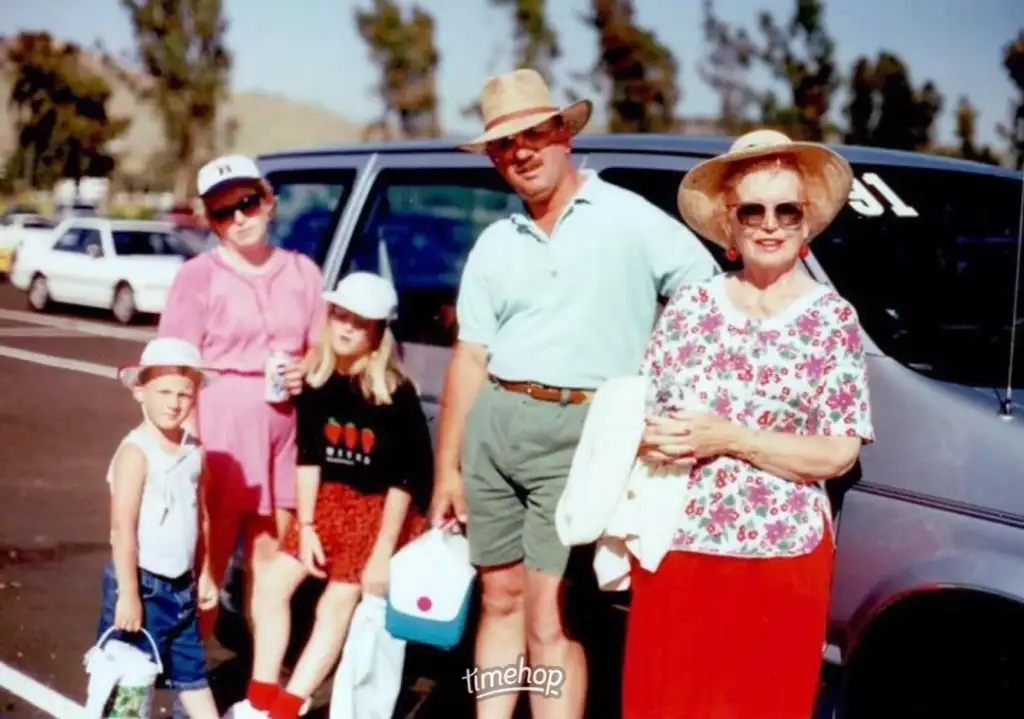 A group of people standing in front of a car